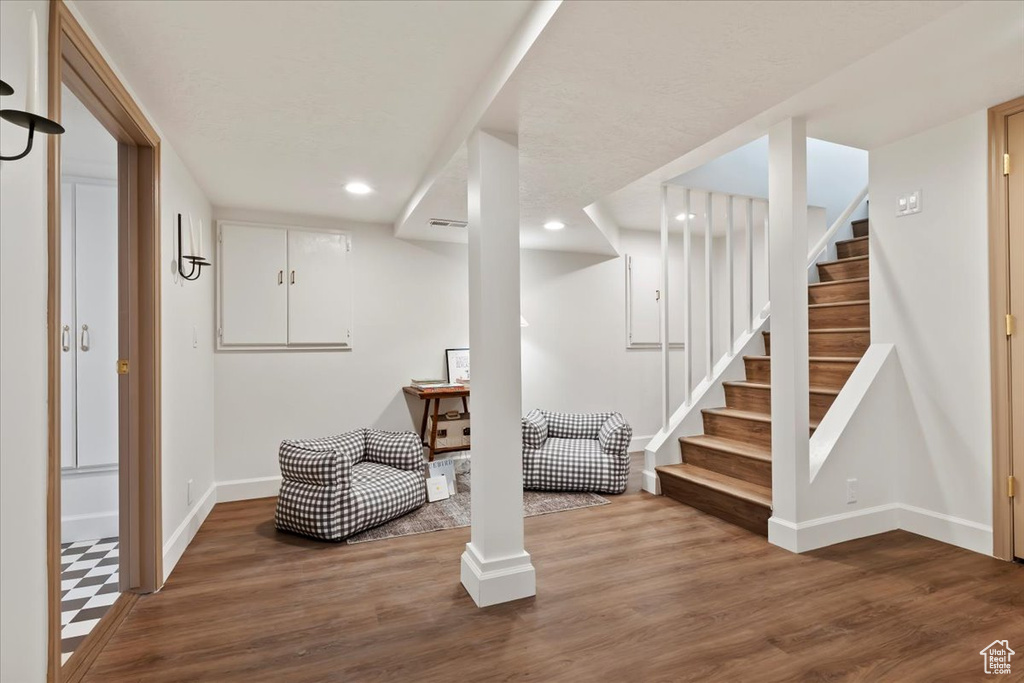 Finished basement featuring baseboards, recessed lighting, wood finished floors, and stairway