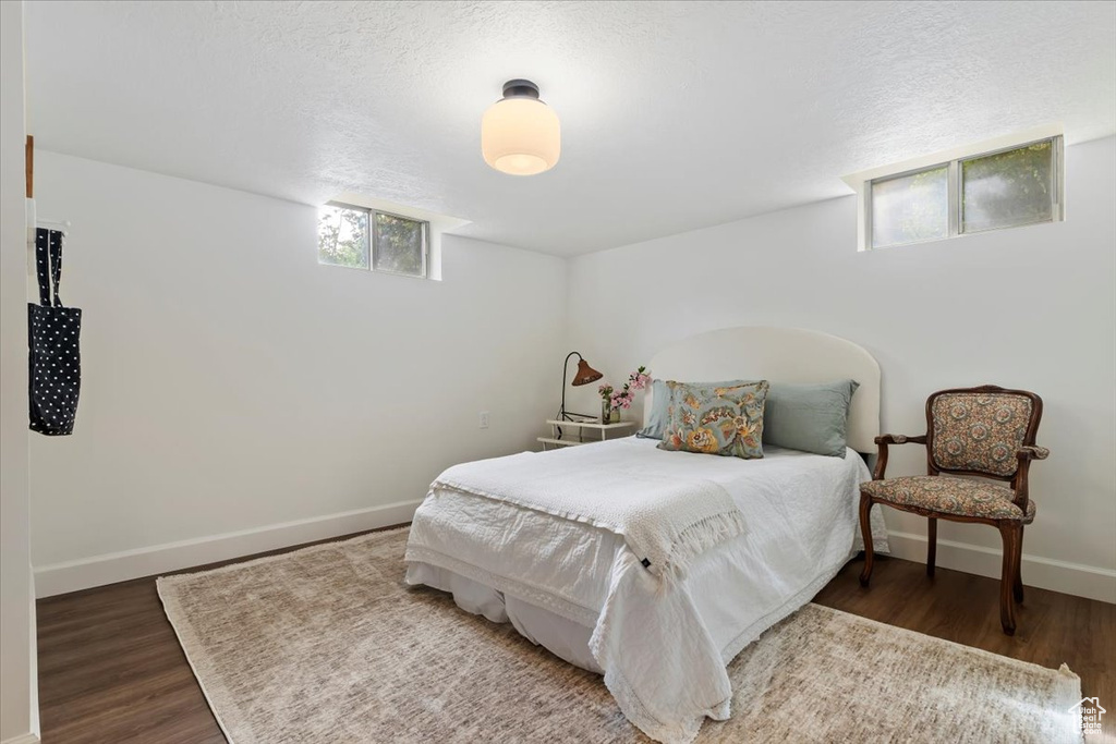 Bedroom featuring baseboards, wood finished floors, and a textured ceiling