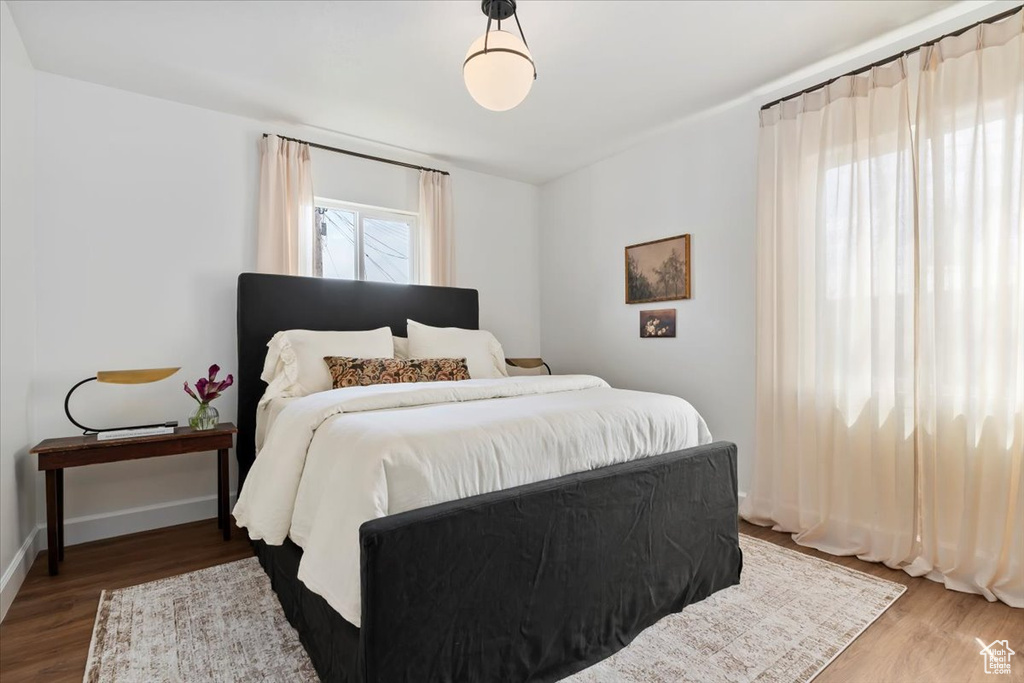 Bedroom with wood finished floors and baseboards