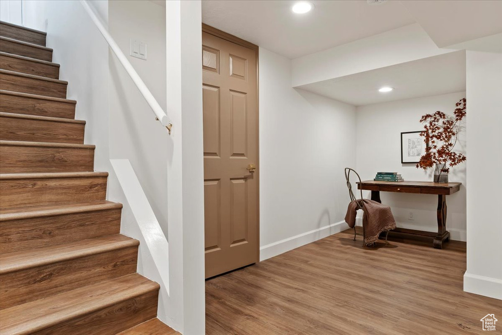 Stairs with baseboards, wood finished floors, and recessed lighting