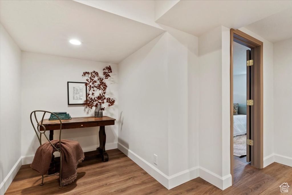 Corridor with wood finished floors, baseboards, and recessed lighting