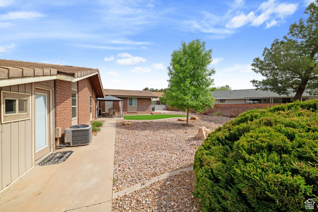 View of yard featuring central air condition unit, a patio, a gazebo, and fence