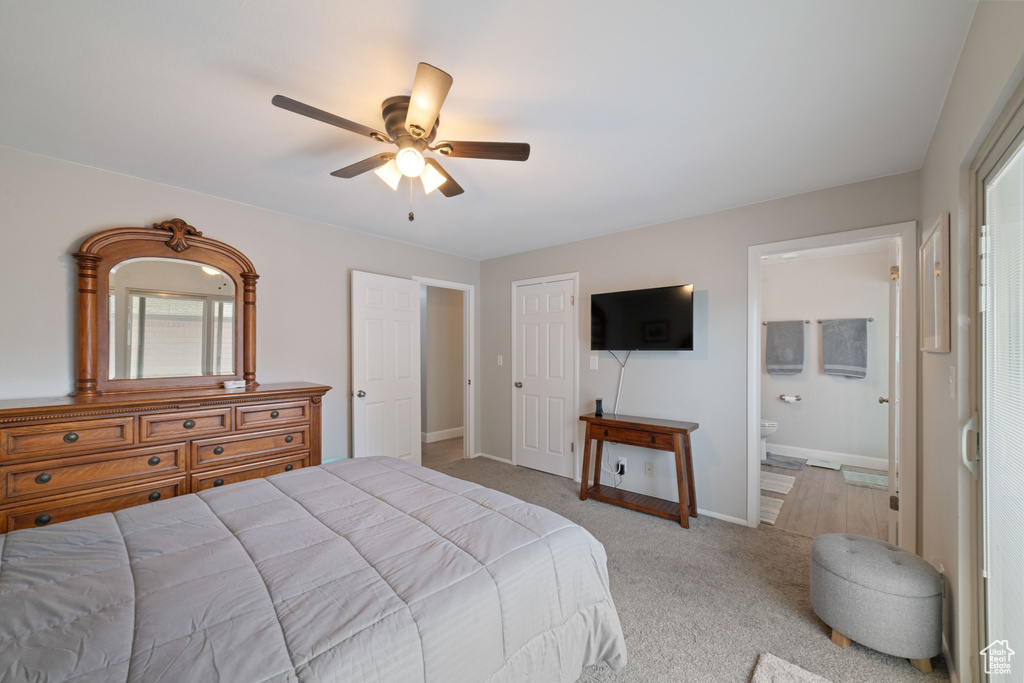 Bedroom with baseboards, ceiling fan, multiple windows, connected bathroom, and light colored carpet
