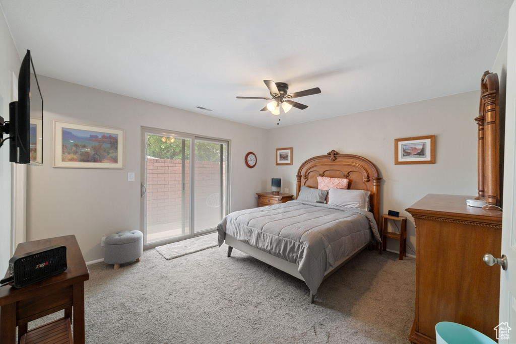 Carpeted bedroom with access to outside and ceiling fan