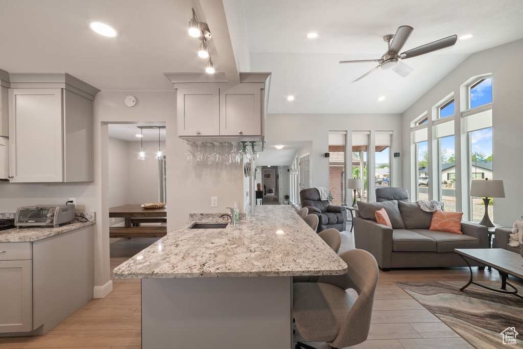 Kitchen with a ceiling fan, a breakfast bar area, a toaster, a sink, and a peninsula