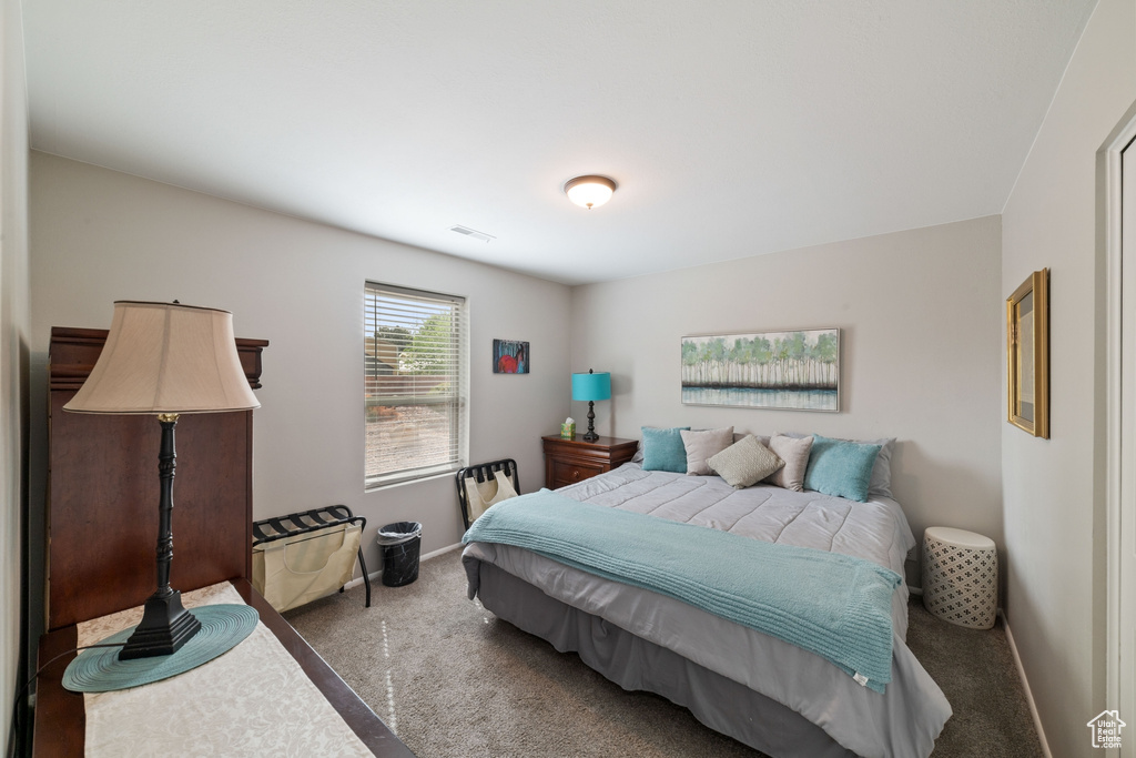 Carpeted bedroom with baseboards and visible vents