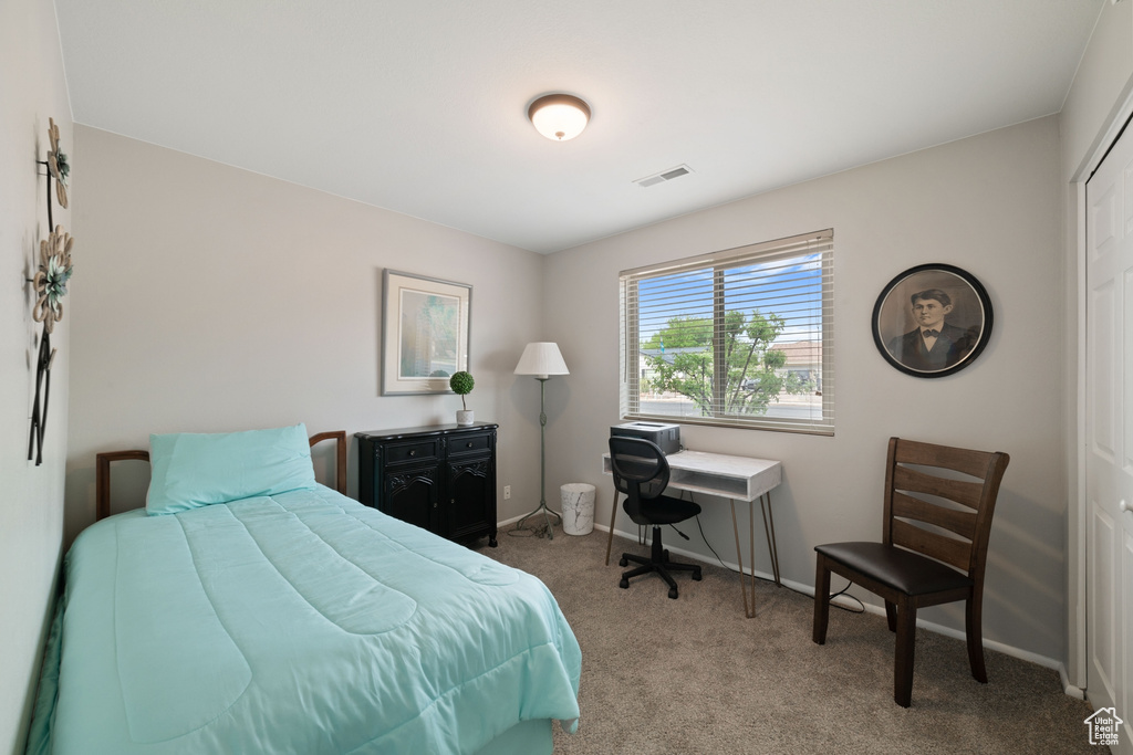Carpeted bedroom featuring visible vents and baseboards