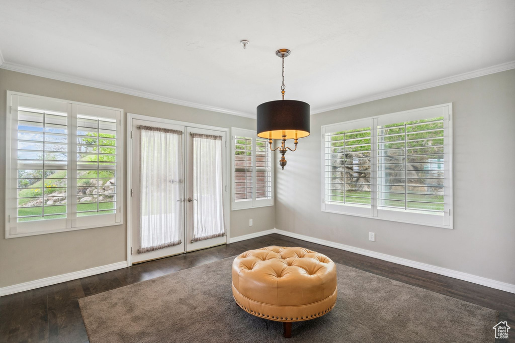 Living area with crown molding, wood finished floors, baseboards, and french doors