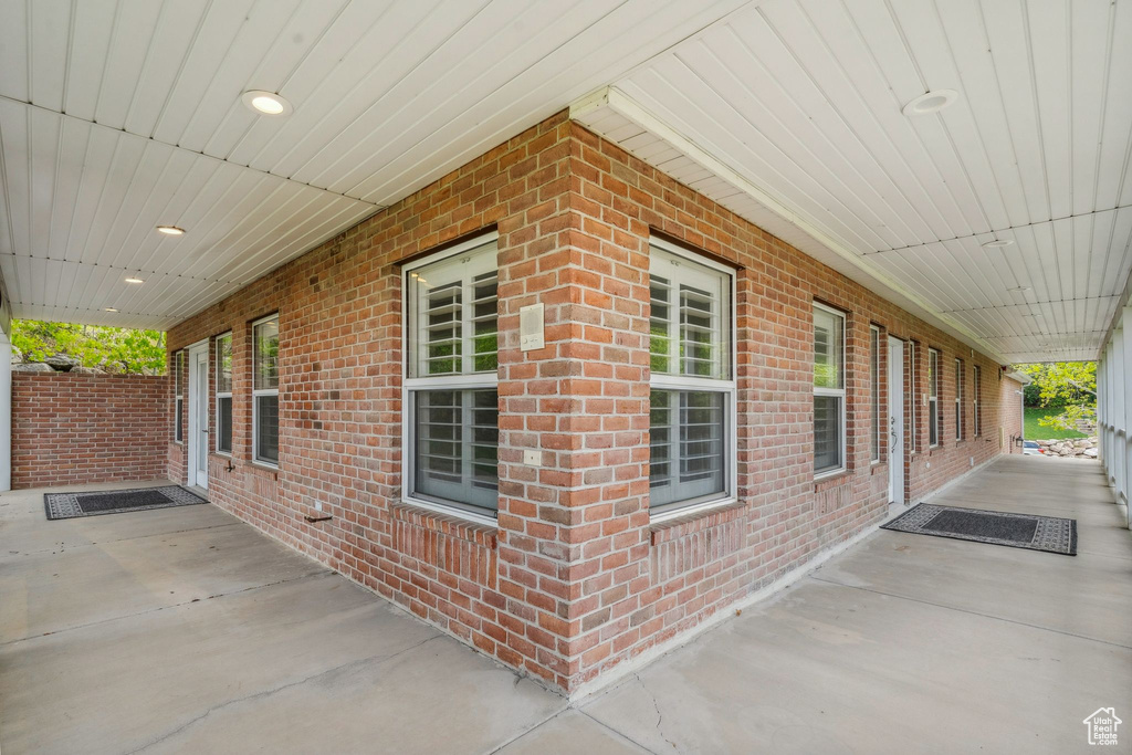View of side of property featuring brick siding and covered porch