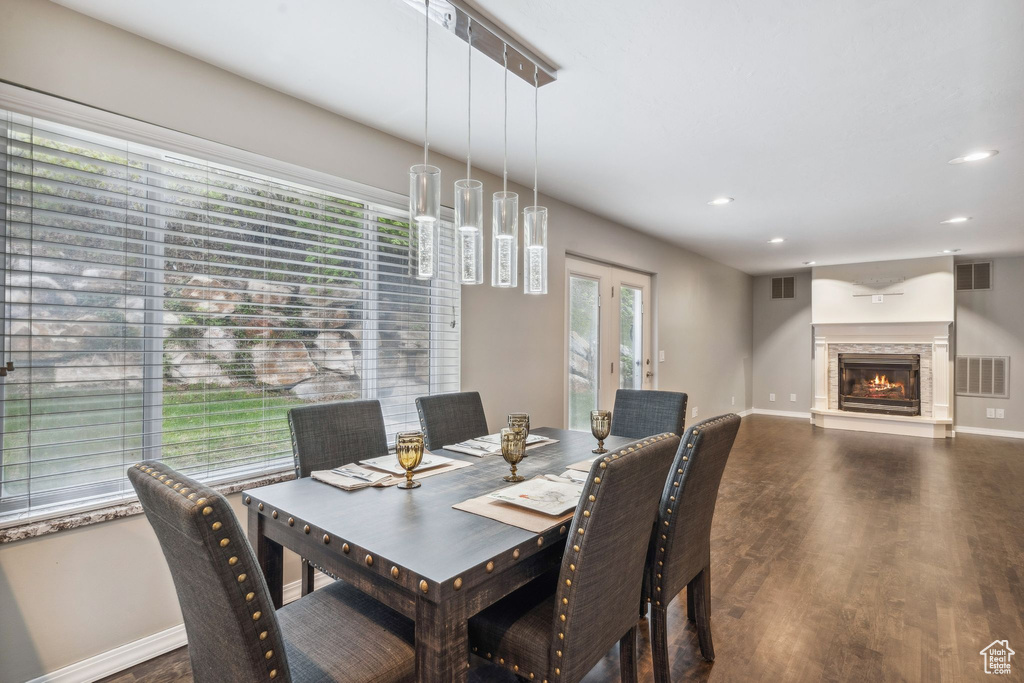 Dining room featuring wood finished floors, baseboards, recessed lighting, and a glass covered fireplace