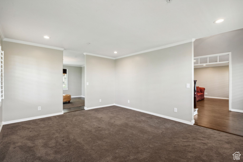 Unfurnished room featuring ornamental molding, baseboards, recessed lighting, and dark colored carpet