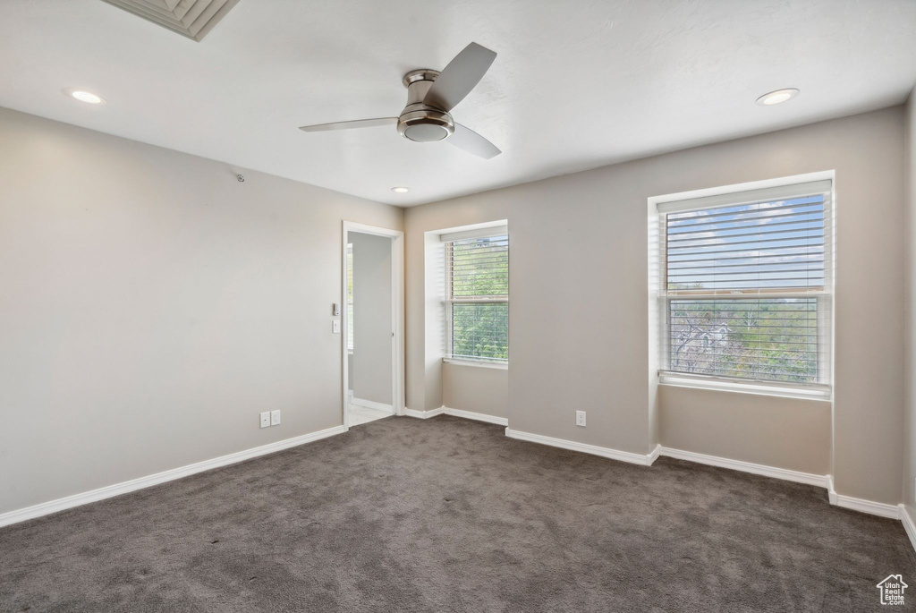 Spare room with a ceiling fan, dark carpet, baseboards, and recessed lighting