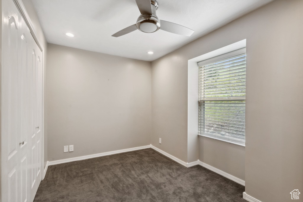 Spare room featuring a ceiling fan, dark colored carpet, baseboards, and recessed lighting