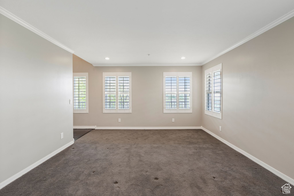 Unfurnished room featuring baseboards, crown molding, dark colored carpet, and recessed lighting