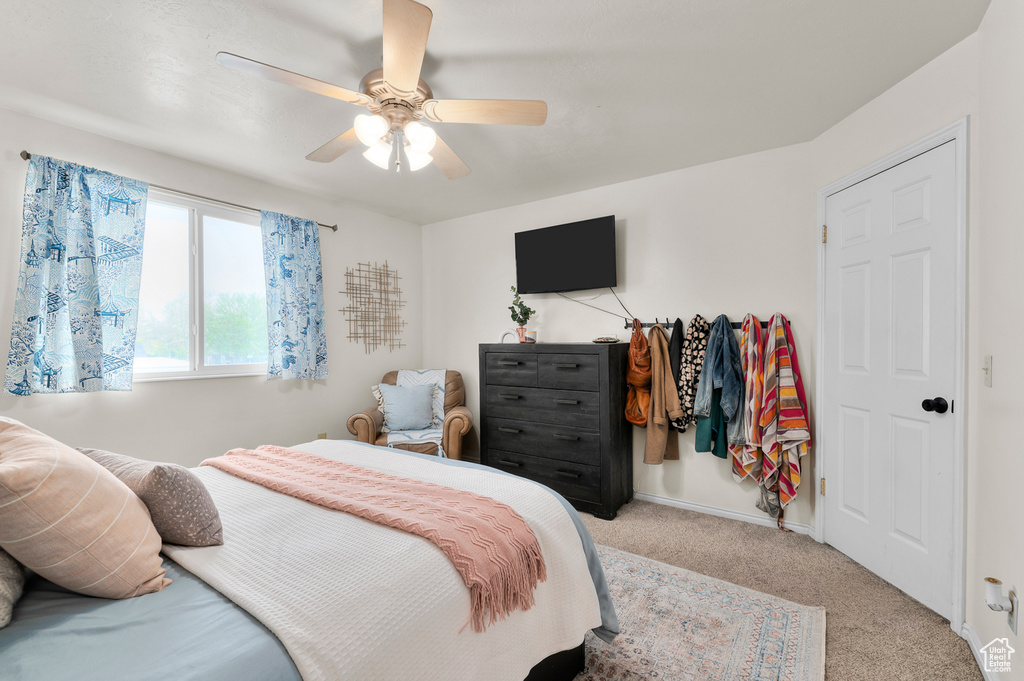 Carpeted bedroom with a ceiling fan and baseboards