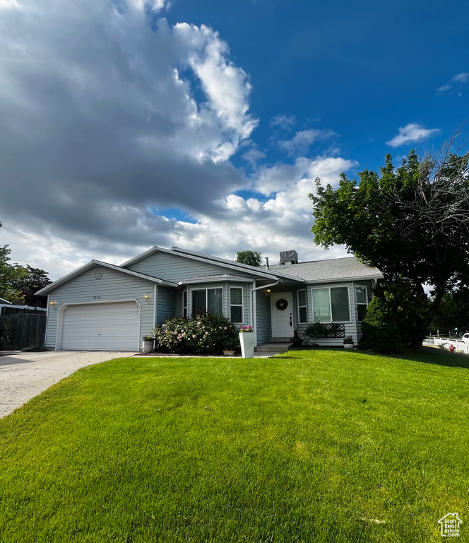 Ranch-style house with a garage, concrete driveway, and a chimney