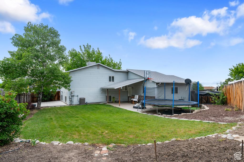 Rear view of property with a patio, a trampoline, and central AC unit