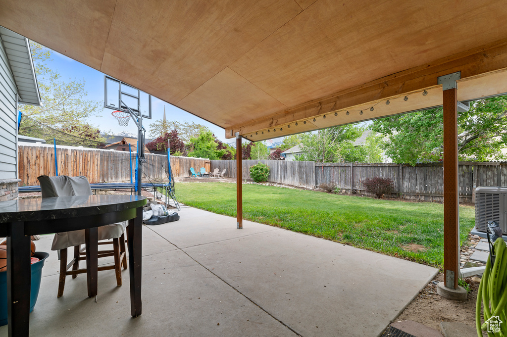 View of patio featuring central air condition unit and a trampoline