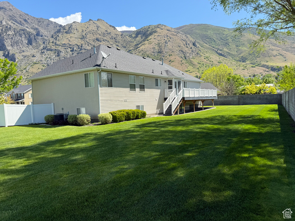 Rear view of property featuring a deck with mountain view and stairs