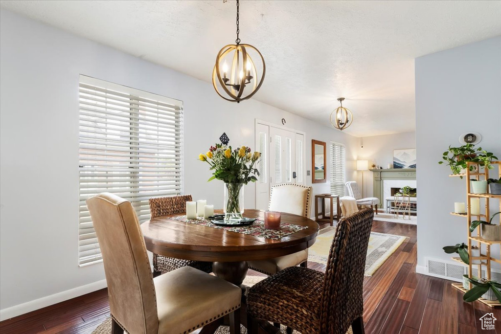 Dining room featuring a chandelier, baseboards, and wood finished floors