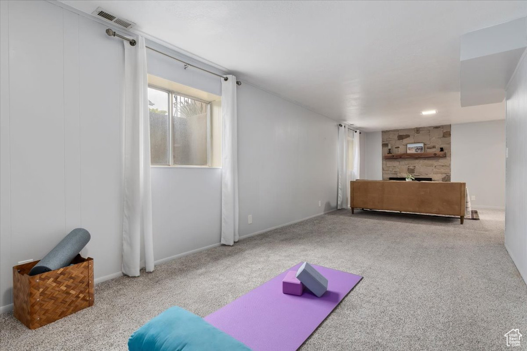 Exercise area featuring carpet flooring, a fireplace, and baseboards
