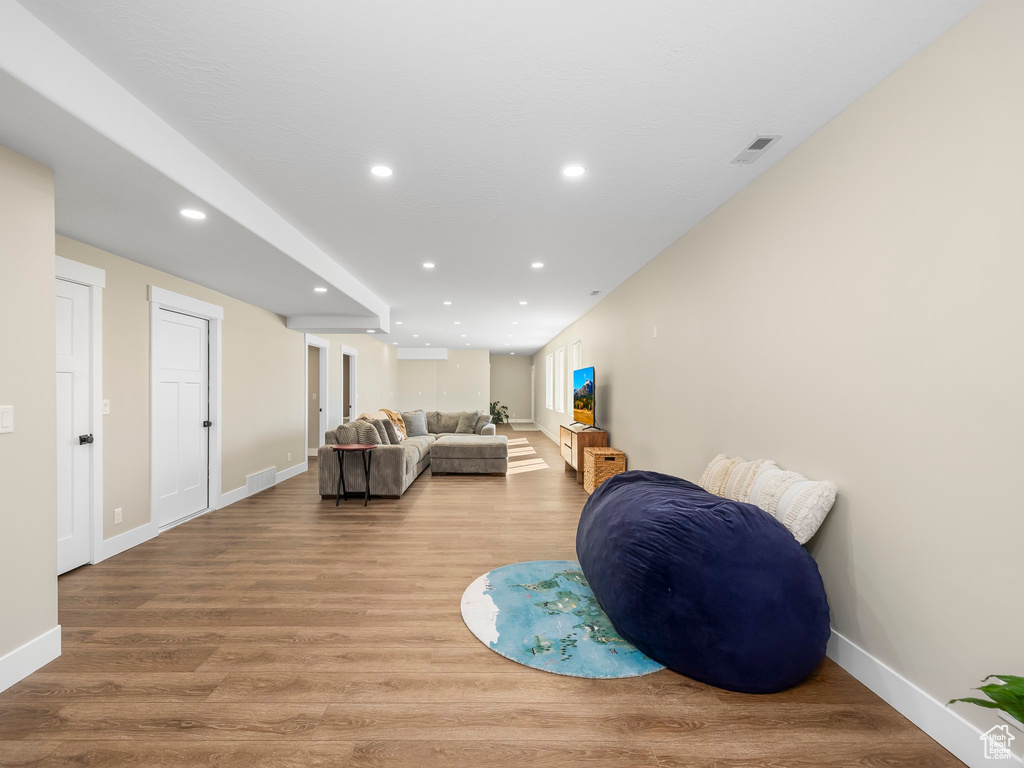 Living area with recessed lighting, baseboards, visible vents, and wood finished floors