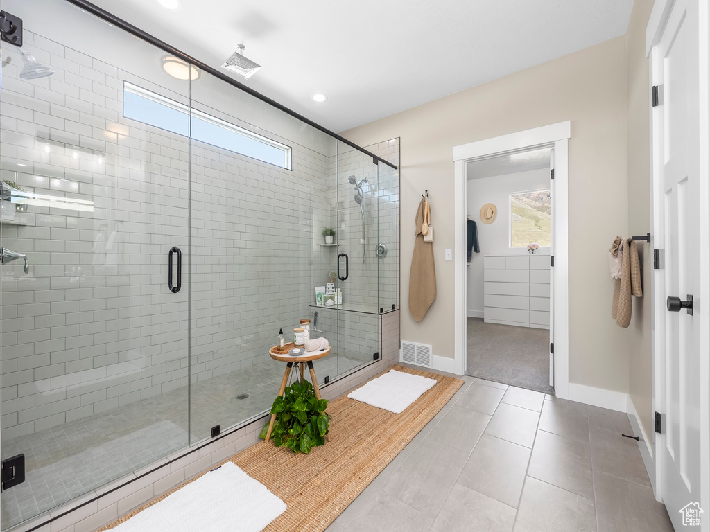 Bathroom with a wealth of natural light, a shower stall, and visible vents
