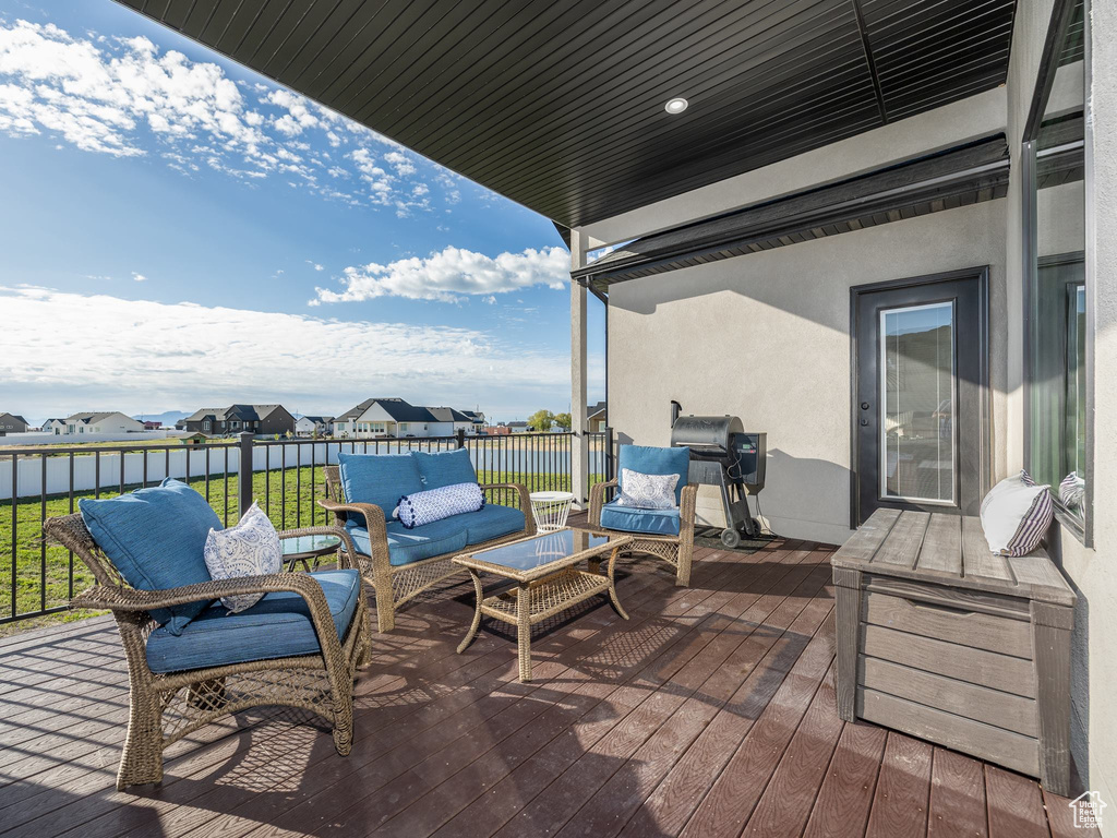 Wooden terrace with a residential view, an outdoor living space, and a grill