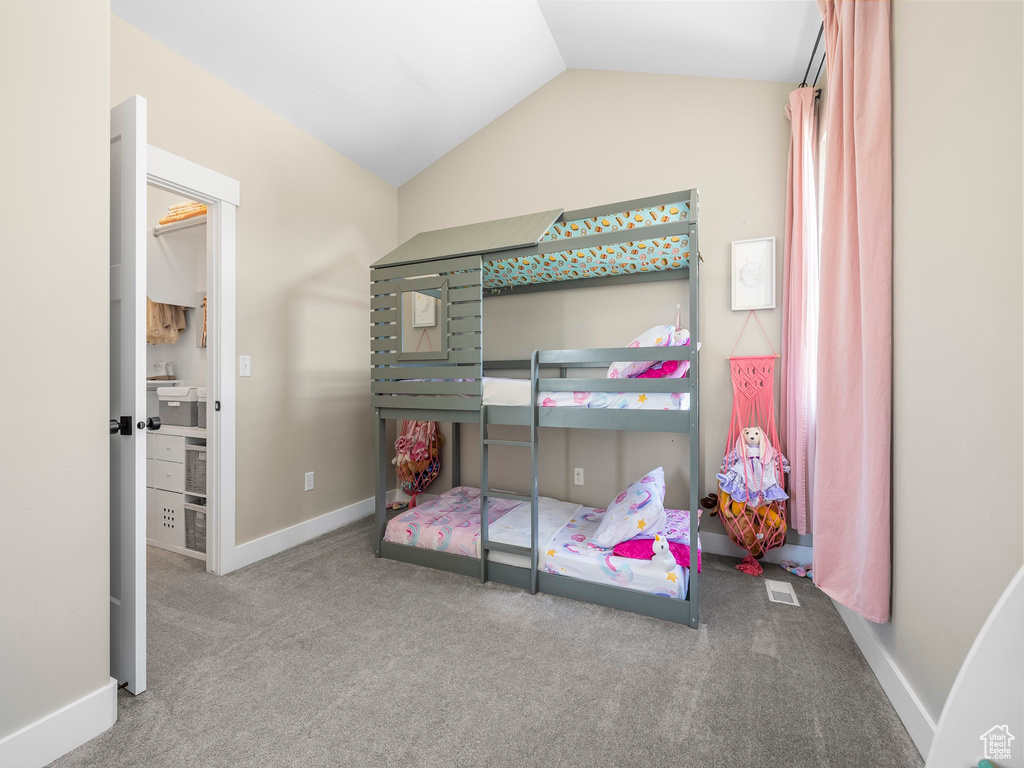 Bedroom featuring baseboards, vaulted ceiling, and carpet