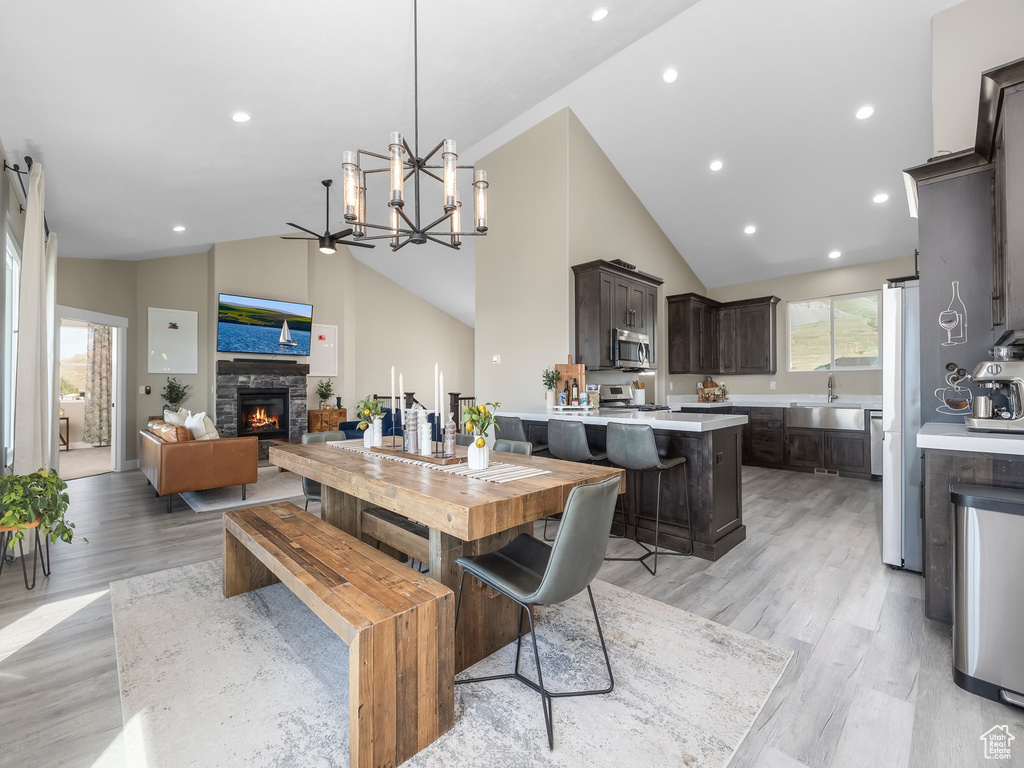 Dining space featuring recessed lighting, a notable chandelier, light wood-style flooring, and a fireplace
