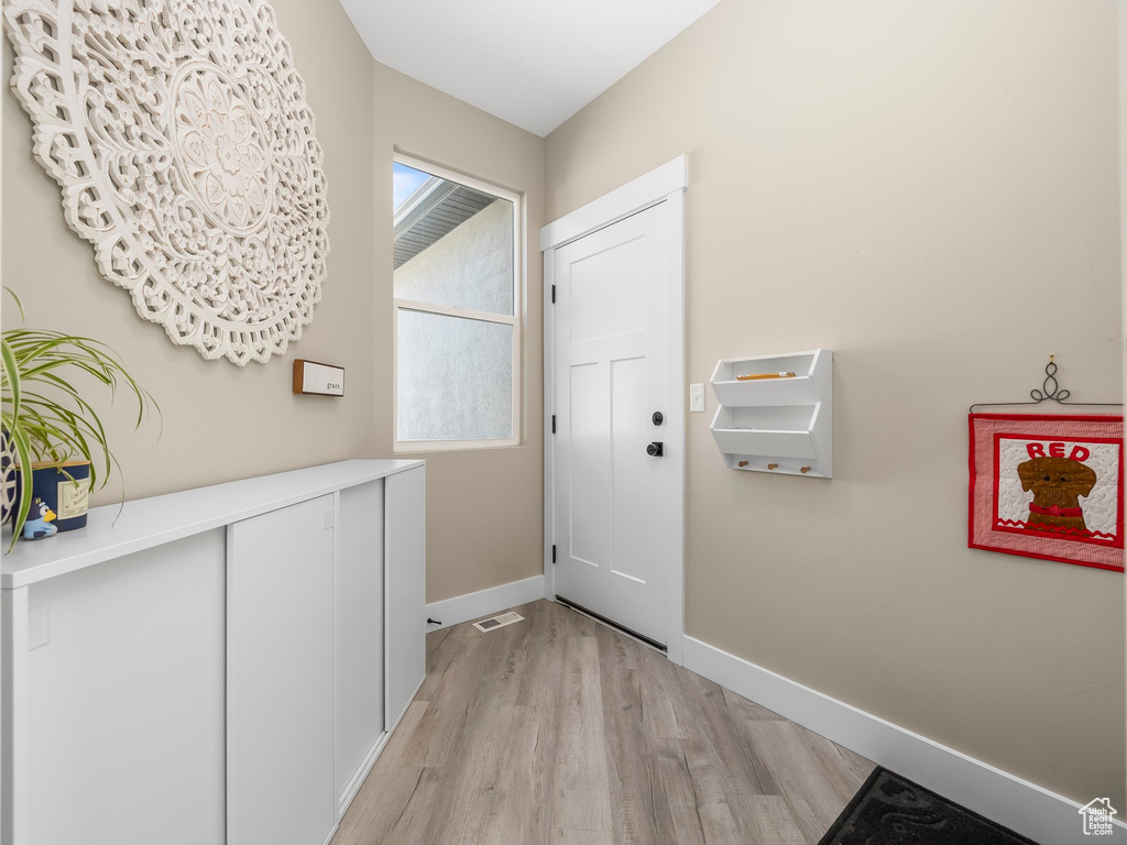 Entryway with baseboards, visible vents, and light wood-style floors