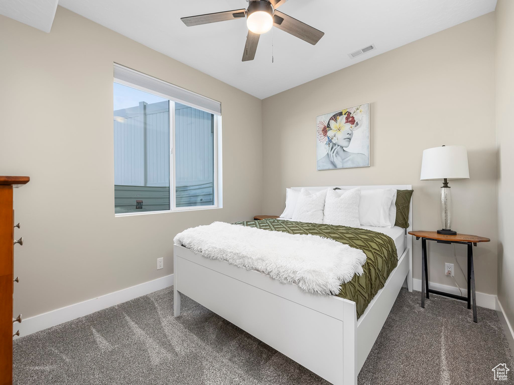 Carpeted bedroom featuring visible vents, a ceiling fan, and baseboards