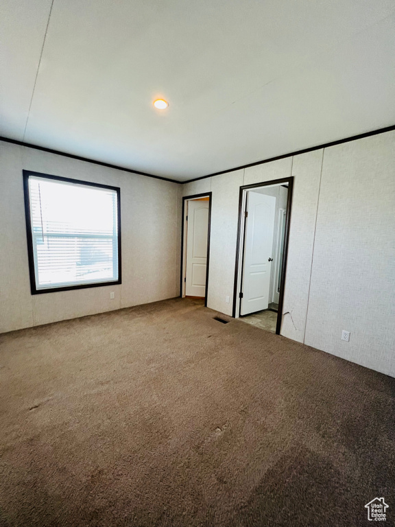 Unfurnished bedroom featuring carpet flooring and multiple closets