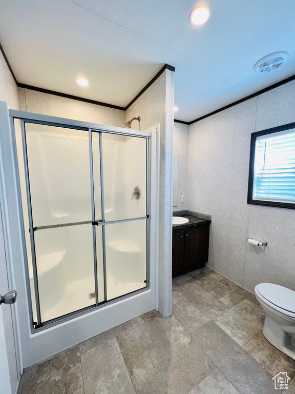 Bathroom with a stall shower, crown molding, toilet, and vanity