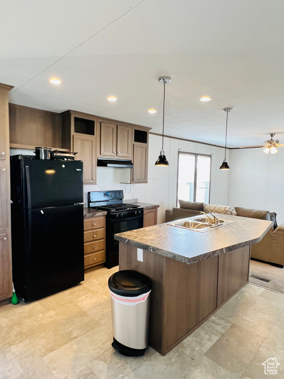 Kitchen featuring recessed lighting, under cabinet range hood, a sink, open floor plan, and black appliances