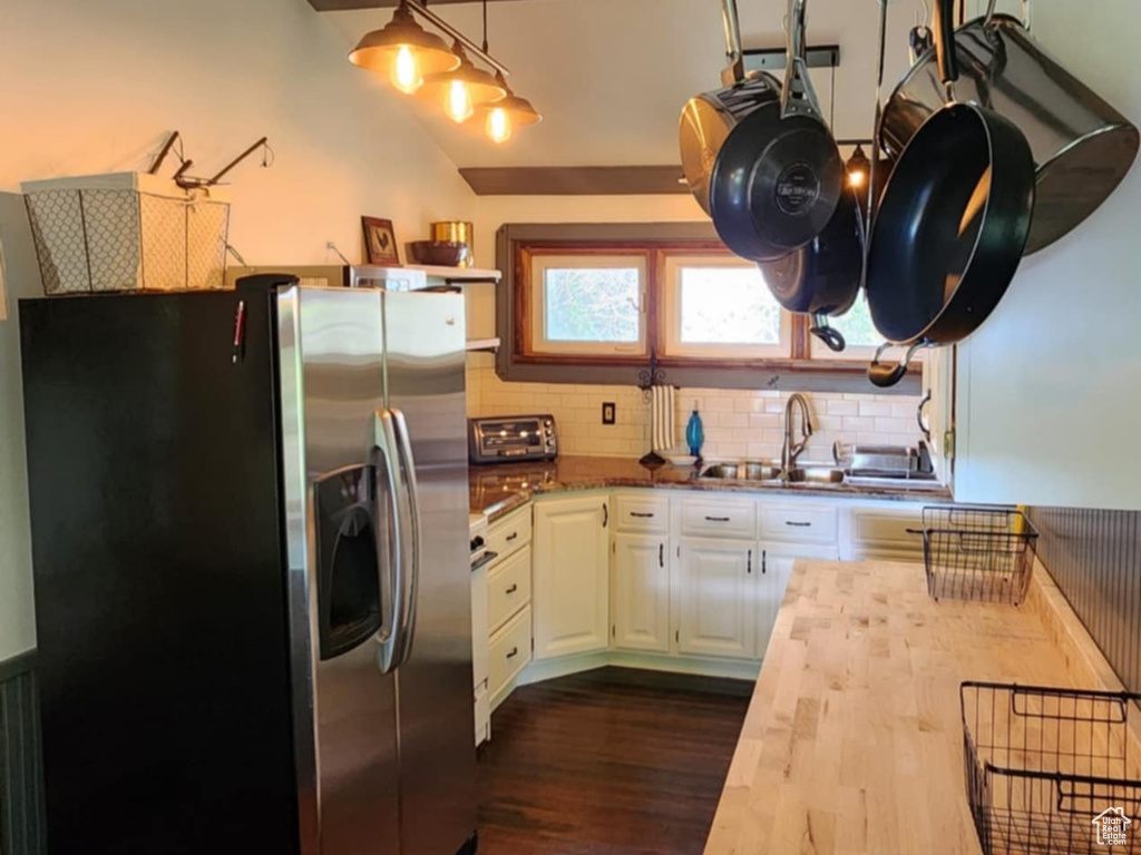 Kitchen with stainless steel fridge with ice dispenser, wood counters, dark wood finished floors, white cabinetry, and a sink