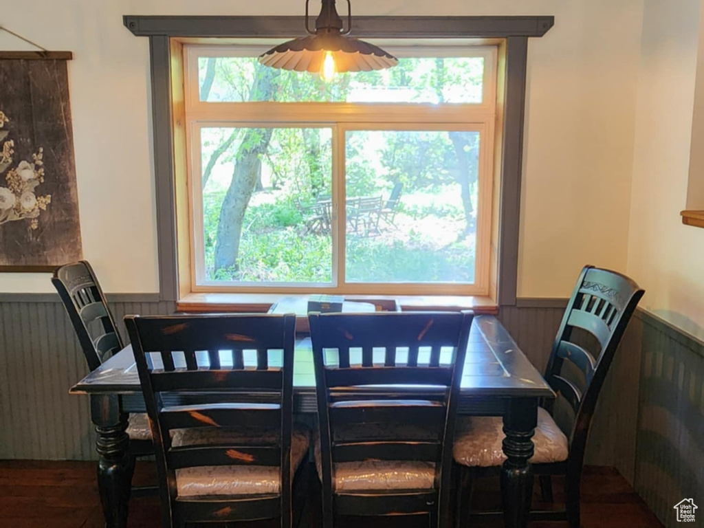 Dining space with a wainscoted wall, hardwood / wood-style flooring, plenty of natural light, and a ceiling fan