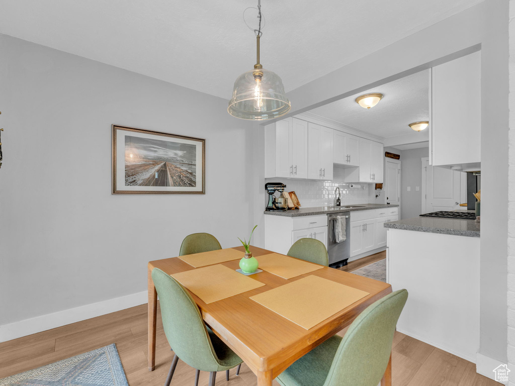 Dining space with light wood-style flooring and baseboards