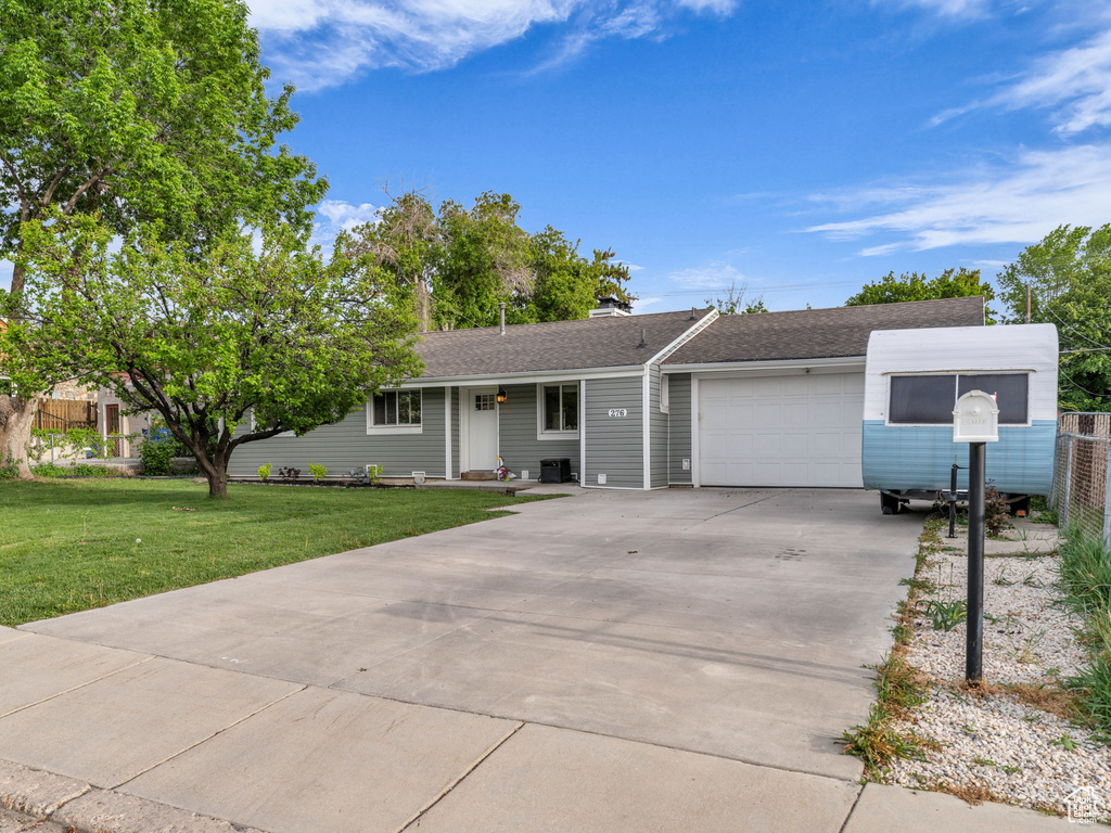 Ranch-style home with a garage, driveway, and a shingled roof