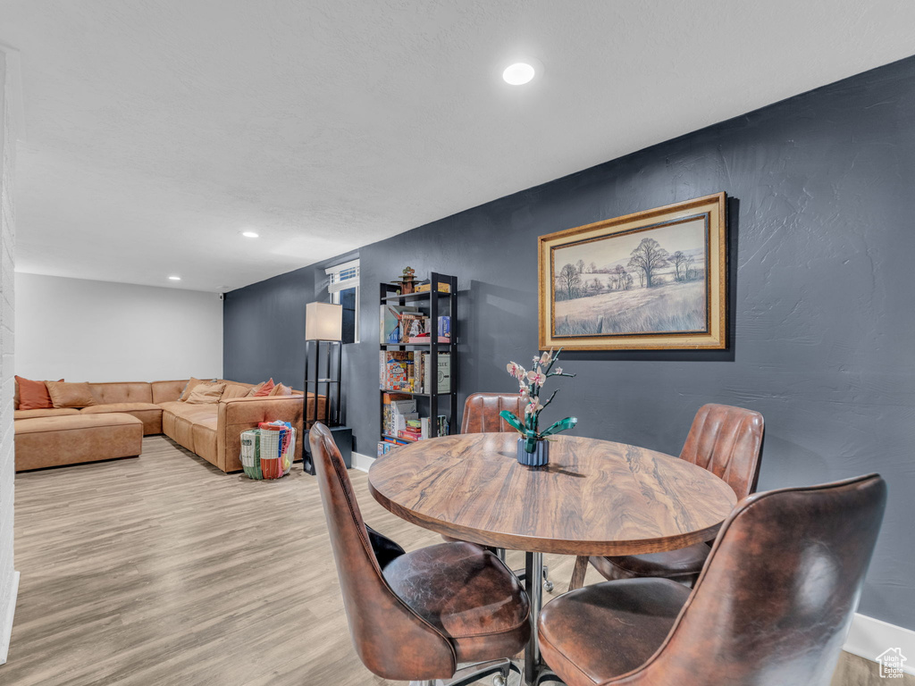 Dining room with light wood-style flooring, recessed lighting, and baseboards