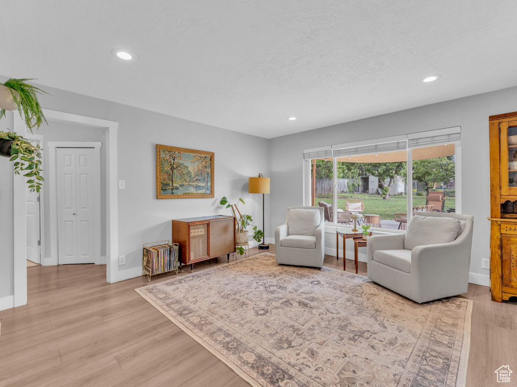 Living area with recessed lighting, baseboards, and light wood-style floors