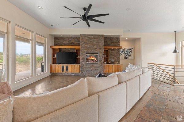 Living area featuring a ceiling fan, recessed lighting, and a fireplace