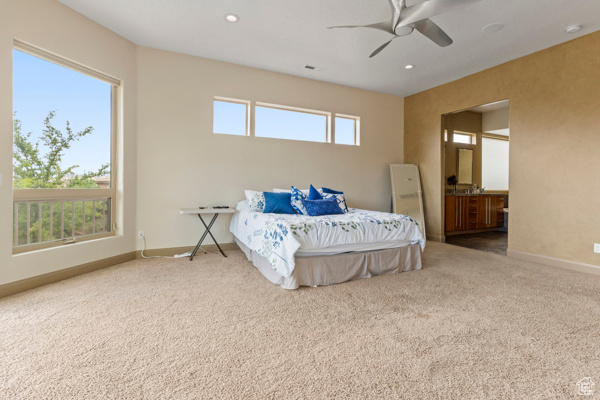 Bedroom with carpet flooring, baseboards, recessed lighting, a ceiling fan, and ensuite bathroom