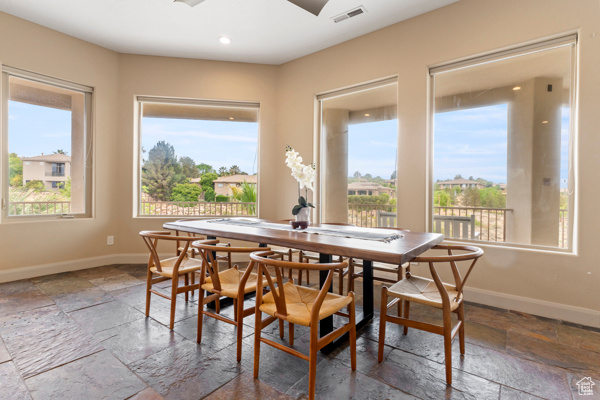 Dining room featuring stone tile flooring, baseboards, and recessed lighting