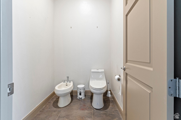 Bathroom with a bidet, toilet, and baseboards