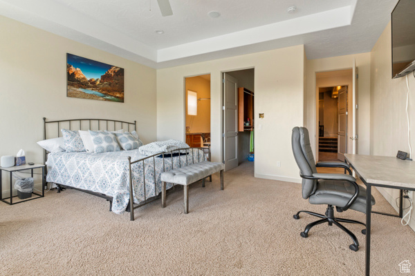 Carpeted bedroom with a ceiling fan and baseboards