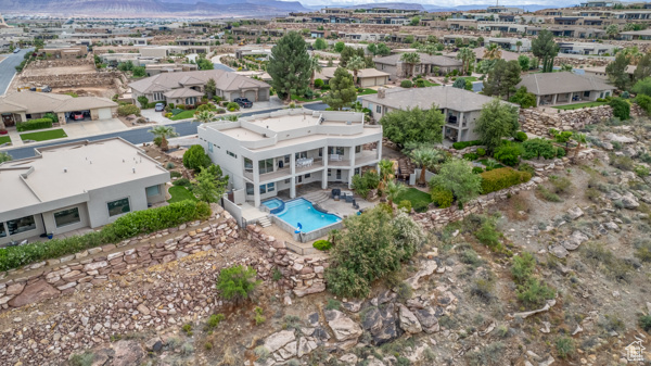 Aerial perspective of suburban area with mountains and a pool