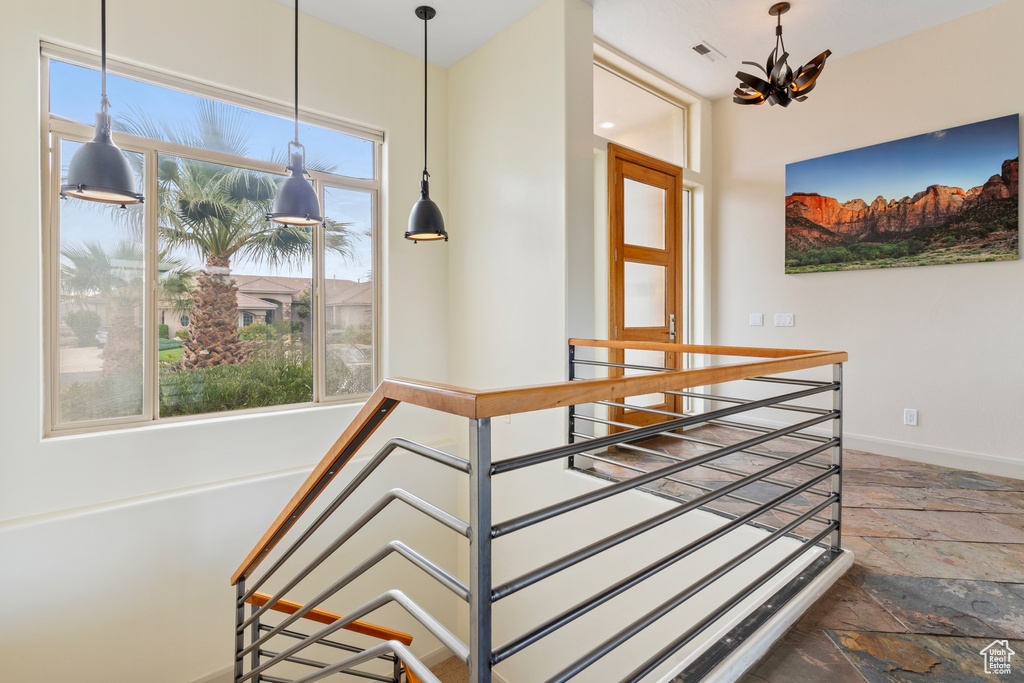 Dining area with a chandelier, stone tile flooring, and baseboards