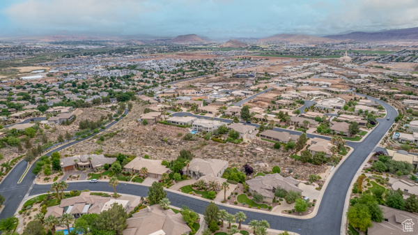Aerial overview of property's location featuring a mountain backdrop and nearby suburban area