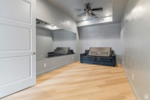 Sitting room with ceiling fan, wood finished floors, and baseboards